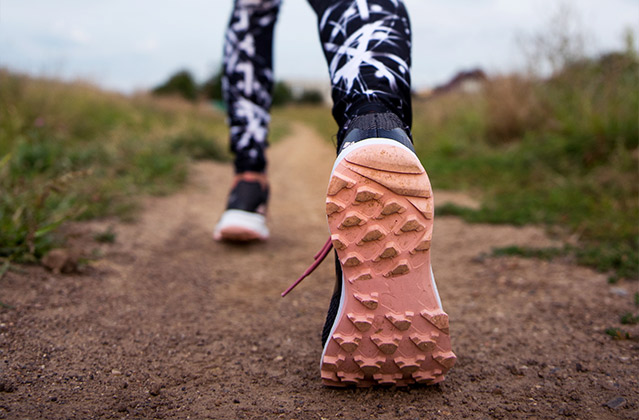 Pies de un runner en un camino de tierra